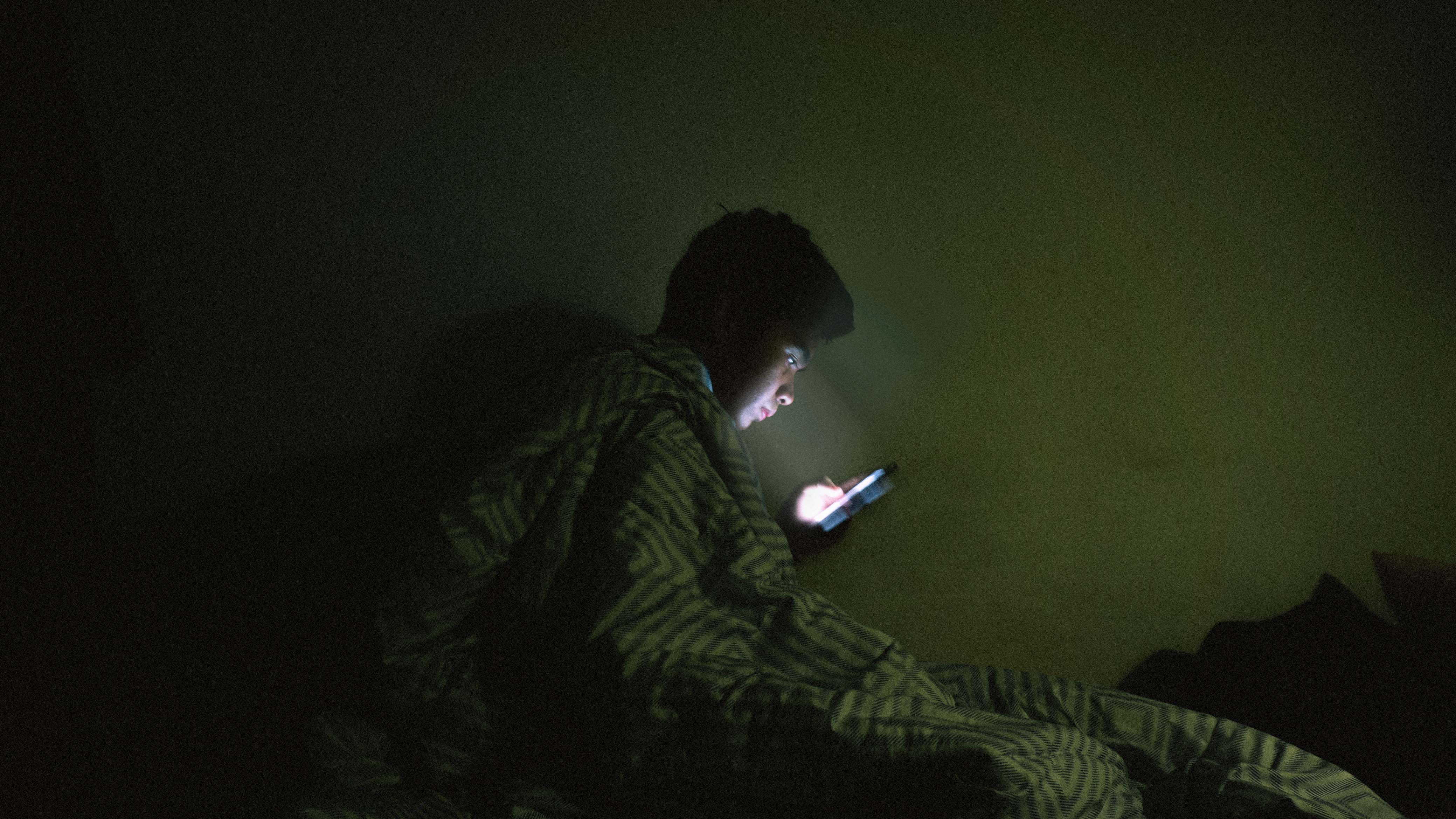 person using mobile phone in bed blue light unable to sleep