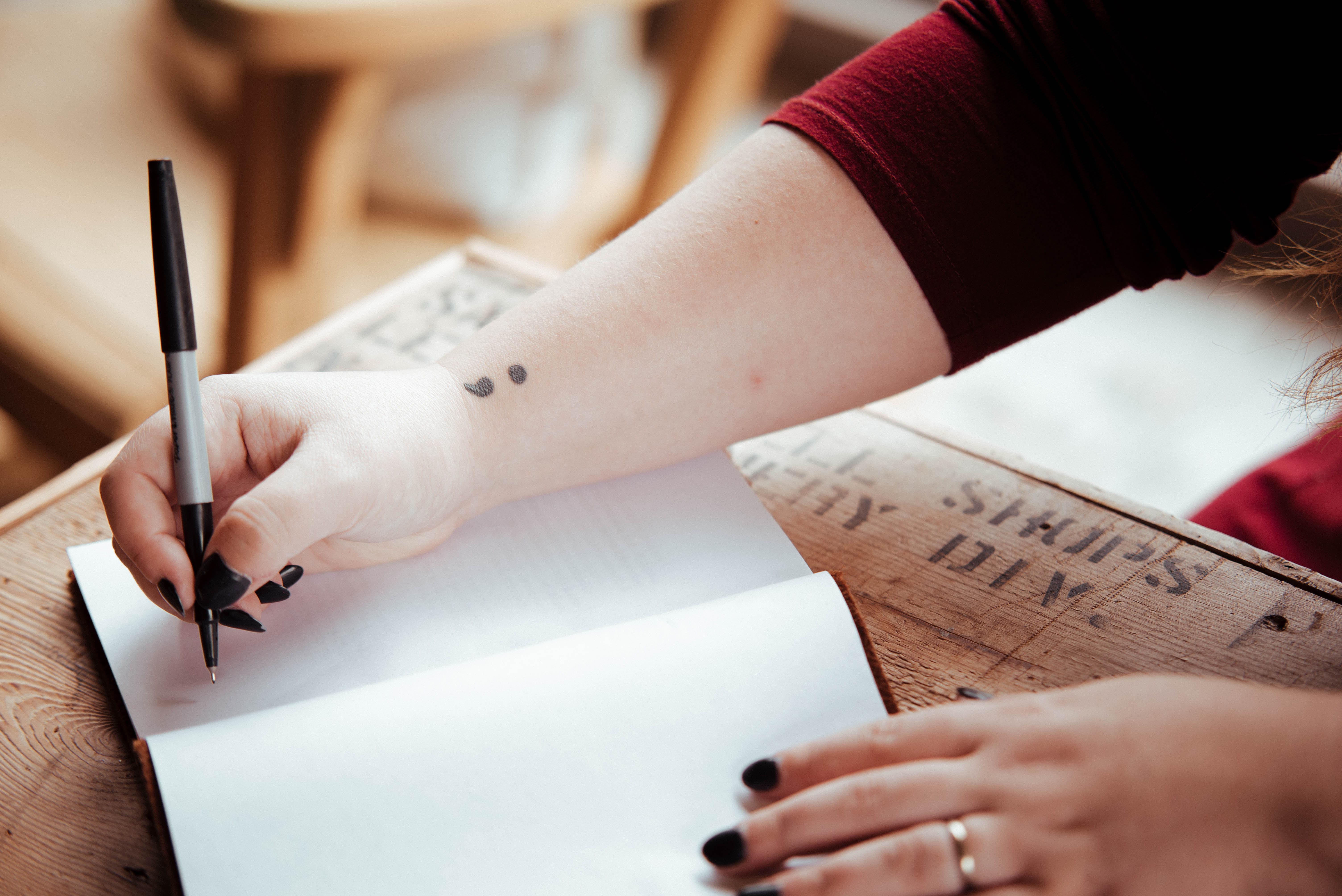 Person writing in book paper and pen writing skills